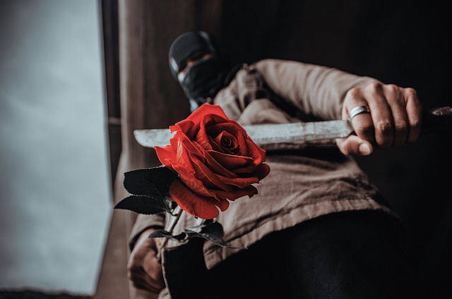 小刀を持つ覆面の男の下からのアップ